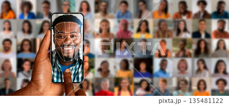A person uses a smartphone for face recognition, showcasing advanced technology. Behind are diverse portraits of people, illustrating the depth of modern identification methods. A person uses a smartphone for face recognition, showcasing advanced technology. Behind are diverse portraits of people, illustrating the depth of modern identification methods. 135481122