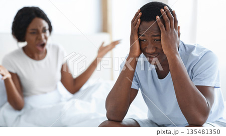 Young married african american couple fighting in bedroom, sad man sitting on bed, woman yelling. Upset black man and woman having fight, thinking about divorce or breaking up, home interior 135481350