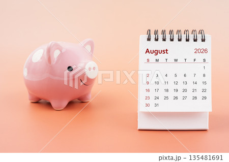 Desk calendar for August 2026 and pink piggy bank. Desk calendar for August 2026 and pink piggy bank. 135481691