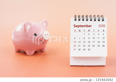 Desk calendar for September 2026 and pink piggy bank. 135481692