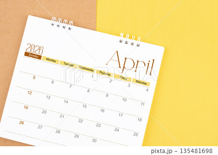 April 2026 desk calendar on brown and yellow, Planning for business. 135481698
