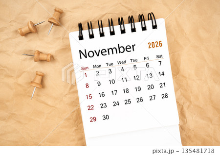 November 2026 white desk calendar with wooden thumbtack on old crumpled paper. November 2026 white desk calendar with wooden thumbtack on old crumpled paper. 135481718