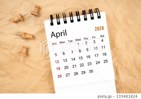 April 2026 white desk calendar with wooden thumbtack on old crumpled paper. April 2026 white desk calendar with wooden thumbtack on old crumpled paper. 135481824