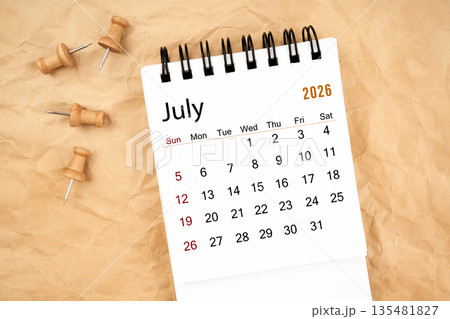 July 2026 white desk calendar with wooden thumbtack on old crumpled paper. July 2026 white desk calendar with wooden thumbtack on old crumpled paper. 135481827