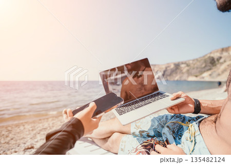 Laptop Beach Work Man - Working on a Laptop while Relaxing on a Beach. 135482124
