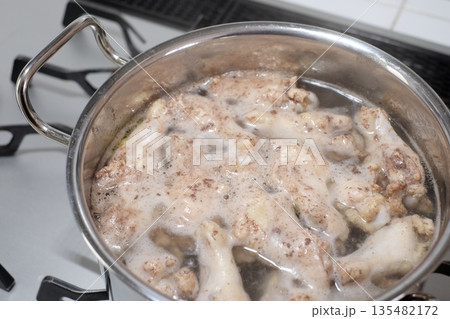 鍋で手羽元を茹でる 135482172
