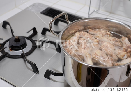 鍋で手羽元を茹でる 135482173