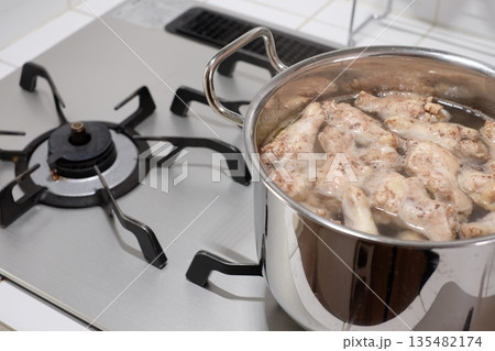 鍋で手羽元を茹でる 鍋で手羽元を茹でる 135482174