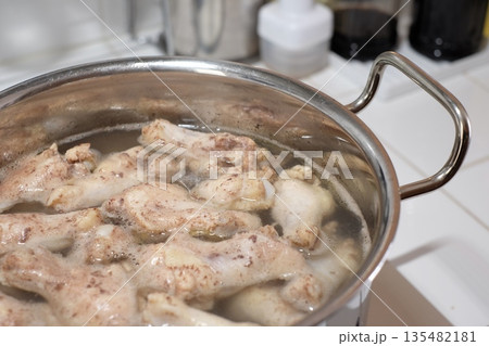 鍋で手羽元を茹でる 135482181
