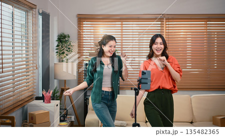 Two girl dancing and making videos for their blogs or social networks. Blogger filming vlog with online content. Two girl dancing and making videos for their blogs or social networks. Blogger filming vlog with online content. 135482365