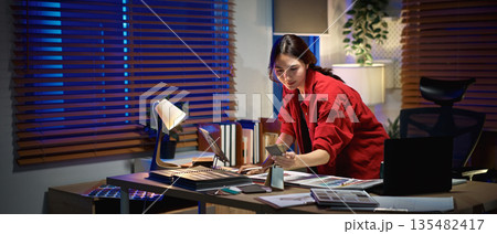Architect interior designer working on new project in office. choosing materials and colors from samples Architect interior designer working on new project in office. choosing materials and colors from samples 135482417