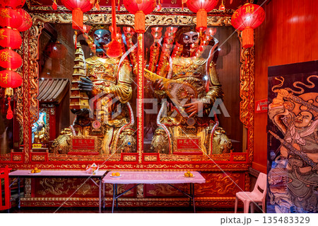 Golden Chinese-style Bodhisattva statues and ornate red interior decorations at Wat Mangkon Kamalawat during a spiritual ceremony Golden Chinese-style Bodhisattva statues and ornate red interior decorations at Wat Mangkon Kamalawat during a spiritual ceremony 135483329