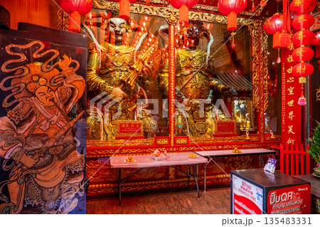 Golden Chinese-style Bodhisattva statues and ornate red interior decorations at Wat Mangkon Kamalawat during a spiritual ceremony 135483331