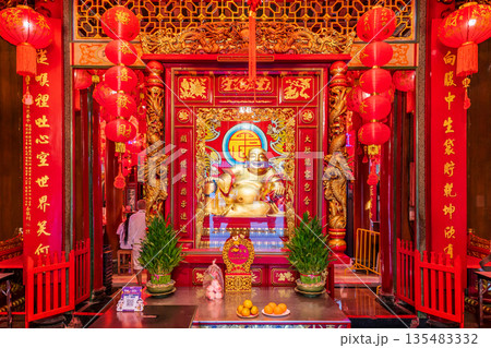 Golden Chinese-style Bodhisattva statues and ornate red interior decorations at Wat Mangkon Kamalawat during a spiritual ceremony 135483332