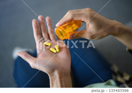 Cropped shot man taking vitamins ginseng pill Cropped shot man taking vitamins ginseng pill 135483566