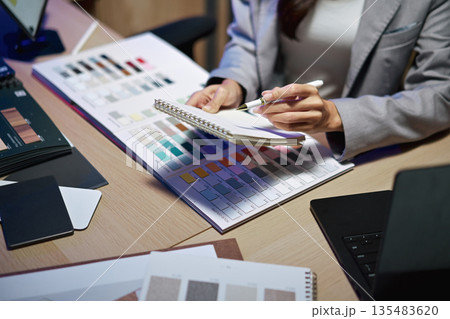 interior designer working on new house project in office. choosing materials and colors from samples interior designer working on new house project in office. choosing materials and colors from samples 135483620
