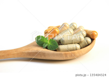 hand hold capsule from organic tree herb for use as a medicine using for health on white background 135484324