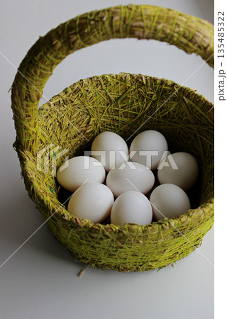Whole white eggs in handmade Basket Isolated On White 135485322
