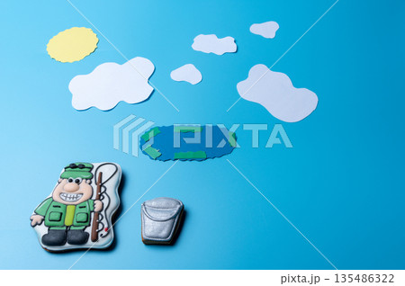 Fisherman with a bucket and fishing rod on the background of the lake. Fisherman with a bucket and fishing rod on the background of the lake. 135486322