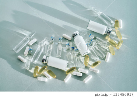 Various medical vials, ampoules, and pills on light background 135486917