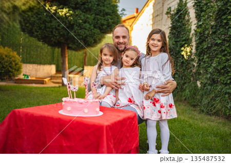 Joyful birthday celebration with family in a sunny garden 135487532