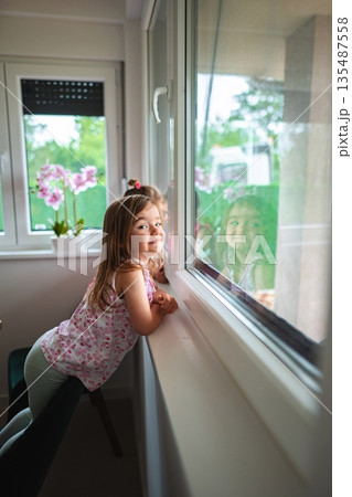 Smiling child enjoying a sunny afternoon indoors Smiling child enjoying a sunny afternoon indoors 135487558