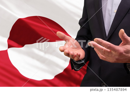 Businessman gesturing in front of the national flag of Greenland 135487894