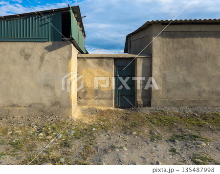 Rustic door against desolate rural buildings during daytime Rustic door against desolate rural buildings during daytime 135487998
