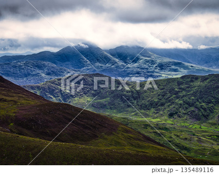 Overcast day on the Coomloughra Horseshoe hiking trail with moody clouds and green hills in Ireland. Overcast day on the Coomloughra Horseshoe hiking trail with moody clouds and green hills in Ireland. 135489116