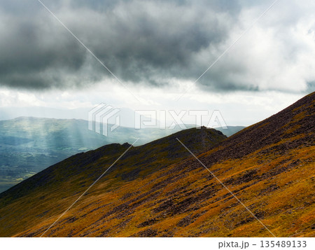 An angled view of a mountain edge where light and shadow collide. 135489133