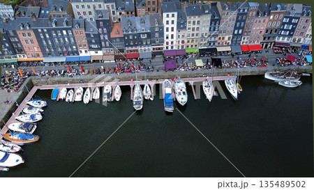 Drone point of view (vertical)  on old embankment and townhouses near harbor with white sailboats. 135489502