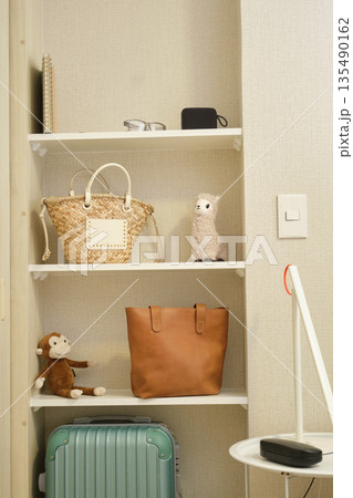 Organized shelving unit displaying lifestyle objects and travel luggage Organized shelving unit displaying lifestyle objects and travel luggage 135490162