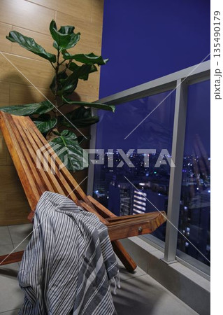 Balcony relaxation with city night view and lounge chair Balcony relaxation with city night view and lounge chair 135490179