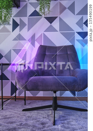 Modern gray armchair with neon lights and geometric wallpaper Modern gray armchair with neon lights and geometric wallpaper 135490199