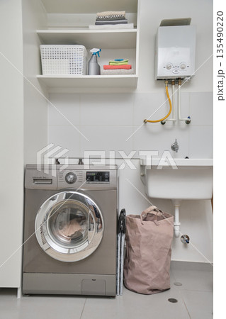 Modern laundry room interior with washing machine and boiler Modern laundry room interior with washing machine and boiler 135490220
