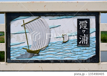 橋の欄干にはめ込まれた、霞ヶ浦のシンボル・帆引き舟のプレート 135490405