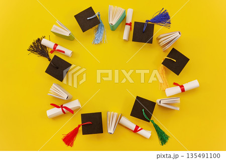 Graduation caps, diplomas, books forming a circle frame Graduation caps, diplomas, books forming a circle frame 135491100