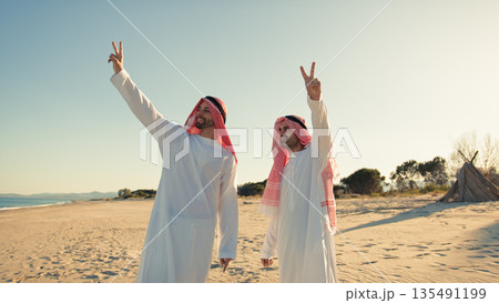 Two Sheiks Making The Victory Gesture In The Desert 135491199