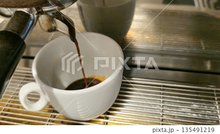 Freshly Brewed Espresso Pouring into White Cup 135491219