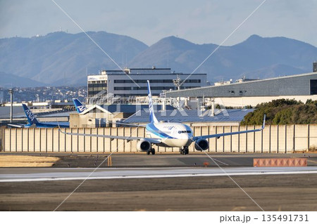 夕方の大阪空港（伊丹空港）　タキシング中の飛行機　大阪府豊中市 135491731