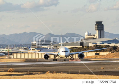 夕方の大阪空港（伊丹空港）　タキシング中の飛行機　大阪府豊中市 135491738
