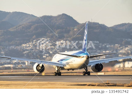 夕方の大阪空港（伊丹空港）　離陸中の飛行機　大阪府豊中市 135491742
