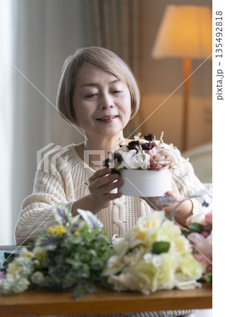 リビングで趣味のフラワーアレンジメントをするシニア女性 自然光 135492818