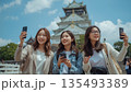 大坂城の天守閣と記念写真を撮る女性 135493389