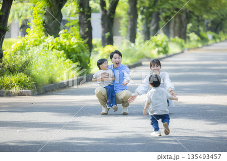 新緑の公園を歩く家族   　  135493457