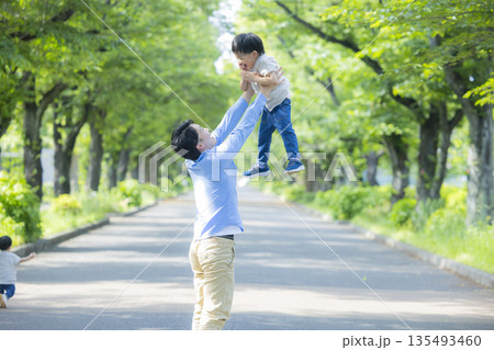 新緑の公園を歩く家族   　  135493460