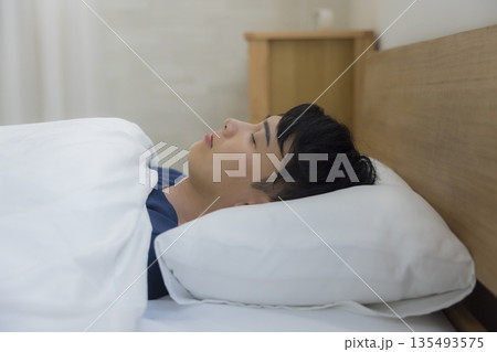ベッドで眠る男性     135493575