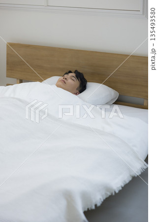 ベッドで眠る男性     135493580