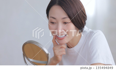鏡を見て微笑む女性 鏡を見て微笑む女性 135494849