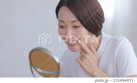 鏡を見て微笑む女性 135494851